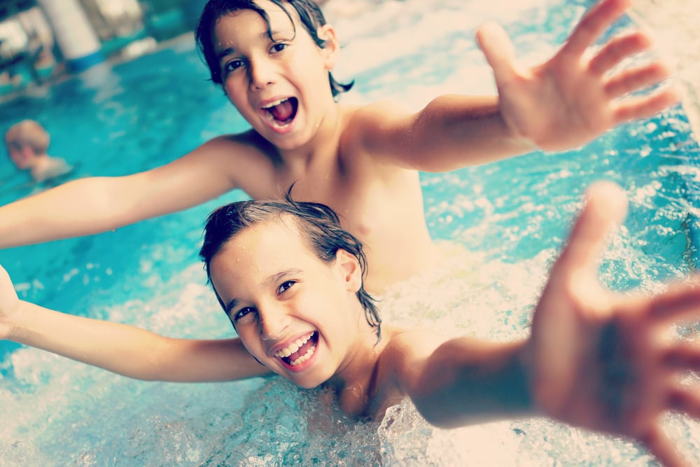 Two happy kids having fun on summer pool (colorized effect)-1